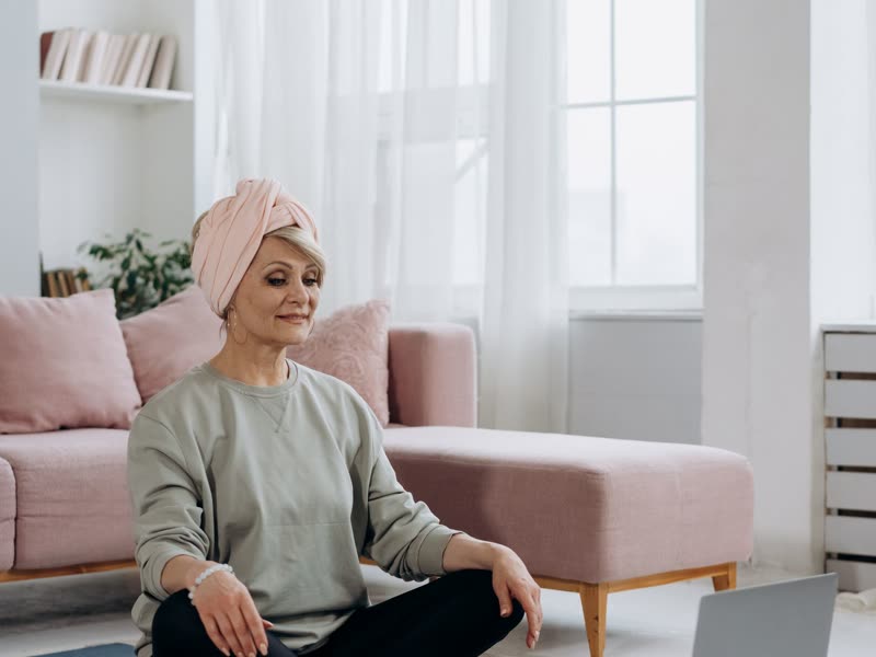 A woman sitting upright and composed on her sofa at home.