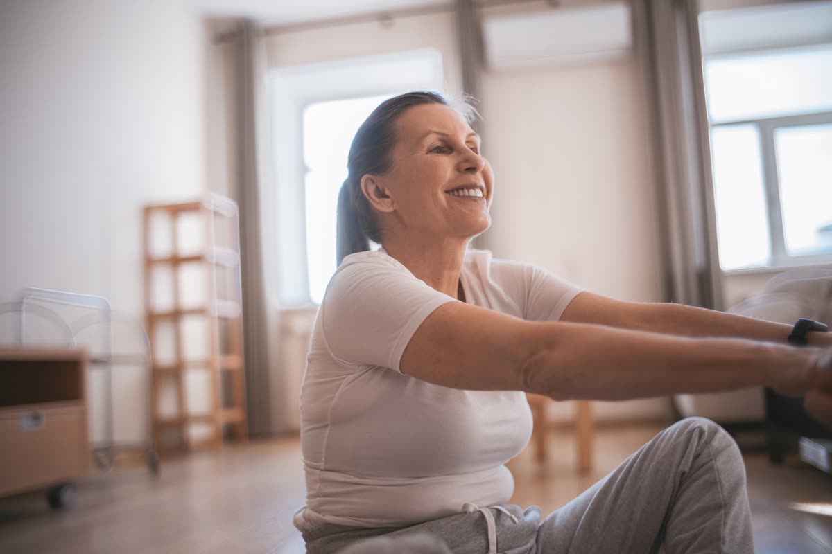 A woman training at home in an ordinary living room, using only a chair.